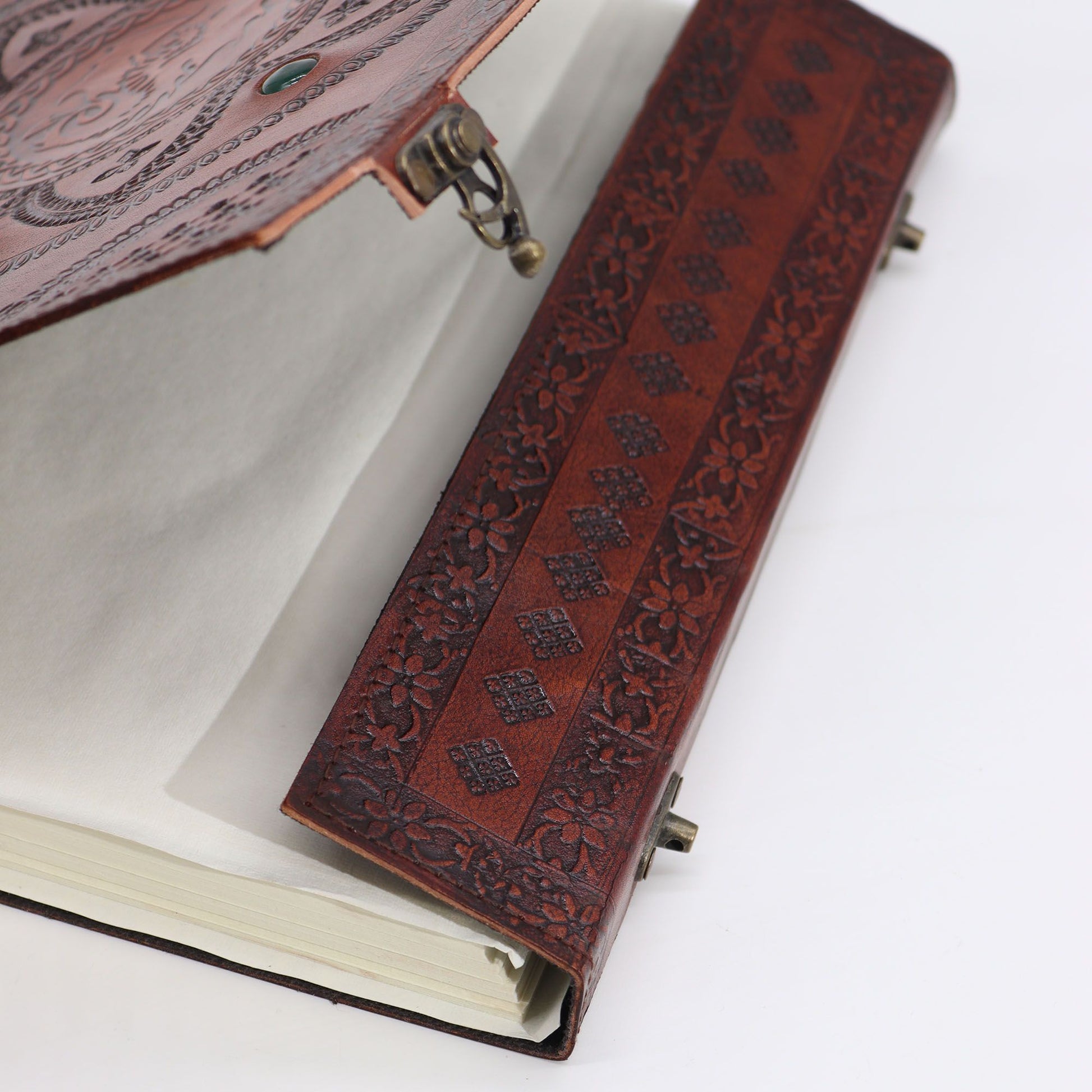 High-quality studio photo showing the texture and detail of the embossed leather and the colorful healing stones on the front cover of a fantasy-themed notebook.